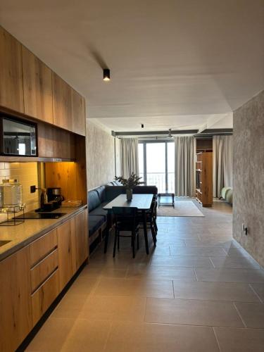 a kitchen and living room with a table and a couch at Departamentos y Suites Índigo in Querétaro