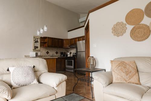 a living room with two white couches and a kitchen at Punta Chame Club and Resort One Bedroom Home in Pajonal