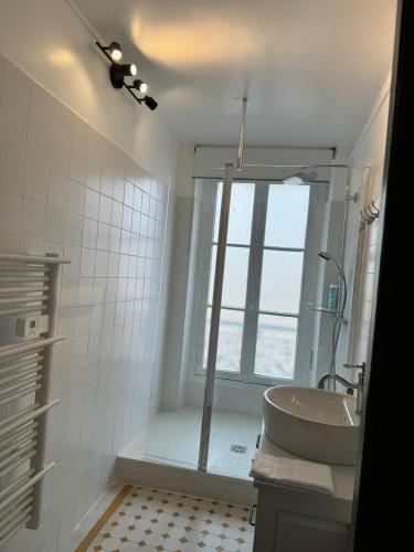 une salle de bain avec une baignoire, un lavabo et une fenêtre dans l'établissement Maison cosy Paris centre avec jardin, à Paris