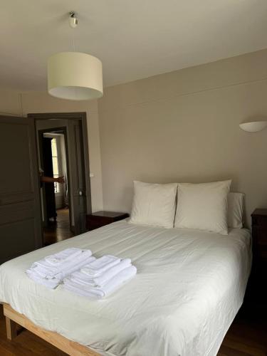 - un lit blanc avec 3 serviettes blanches dans l'établissement Maison cosy Paris centre avec jardin, à Paris