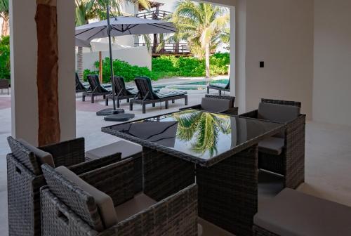 a dining area with chairs and a glass table at Beachfront Hotel Boutique DK in Holbox Island