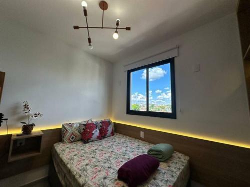 a living room with a couch and a window at APTO TESLA 02,com piscina e Ar condicionado in São Carlos