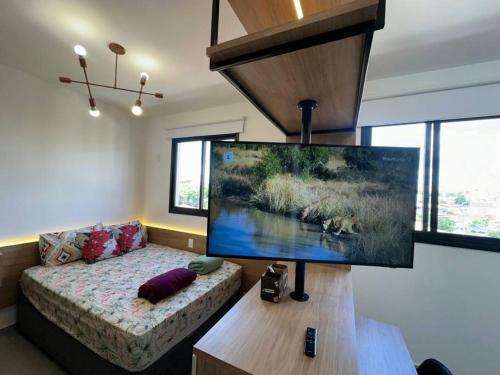 a living room with a large flat screen tv on a table at APTO TESLA 02,com piscina e Ar condicionado in São Carlos