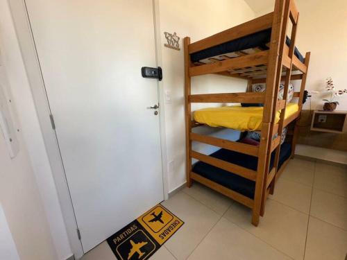 a room with bunk beds and a door with a rug at APTO TESLA 02,com piscina e Ar condicionado in São Carlos