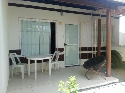 a patio with a table and chairs in a building at Casa Jardim PINHEIROS in Maceió
