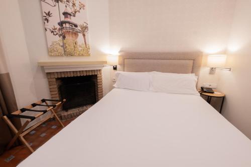 a bedroom with a bed and a fireplace at La Almoraima Hotel in Castellar de la Frontera