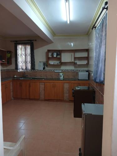 a large kitchen with wooden cabinets and a window at Sunset Villa in Mombasa