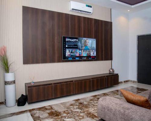 a living room with a flat screen tv on a wall at Nine A Apartment in Asaba