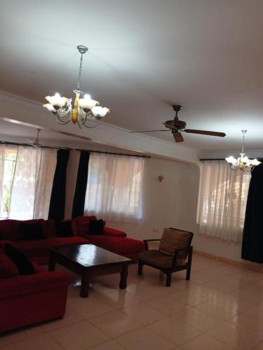 a living room with a couch and a ceiling fan at Sunset Villa in Mombasa