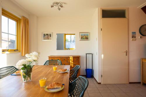 a dining room with a wooden table and chairs at Tulip Beach in De Zandloper