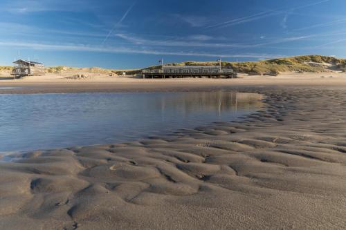 a beach with ripples in the sand next to the water at Tulip Beach in De Zandloper