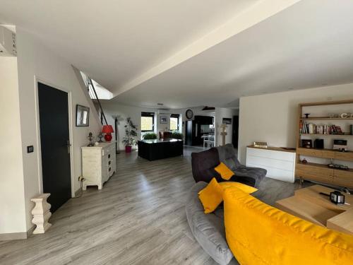 a living room with a yellow couch and a living room at Loft au bord de l'eau in Nevers