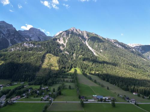 an aerial view of a mountain with a green field at Mountain Hotel & Hostel in Ramsau am Dachstein
