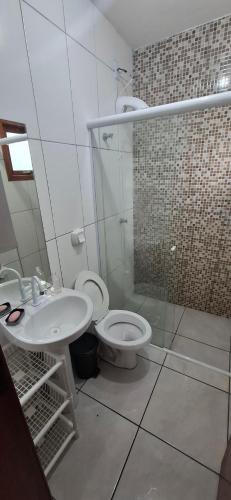 a bathroom with a toilet and a sink at Casa aconchegante em nova tramandai centro in Tramandaí