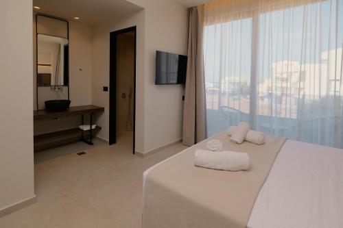 a hotel room with a bed with towels on it at The Z Suites in Gournes