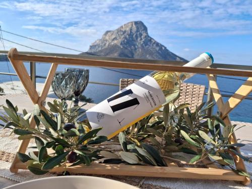 a bottle of wine sitting on a table with a plant at Aegean Whisper in Masouri