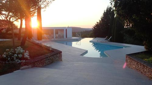 - une piscine au coucher du soleil en arrière-plan dans l'établissement Maison Terral, piscine privée, entre Sarlat et Rocamadour, à Calès
