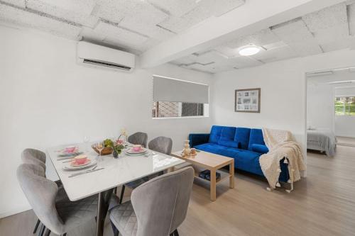 a living room with a blue couch and a table at Tranquil Retreat Ideal Loc in Brisbane