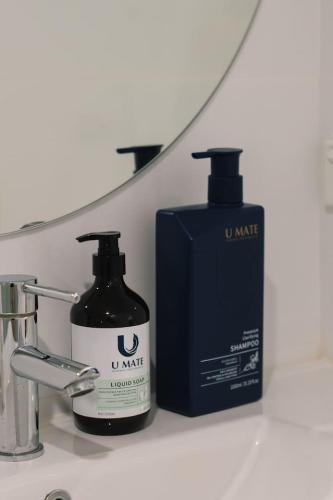 a bathroom sink with a bottle of mouthwash and a soap dispenser at Tranquil Retreat Ideal Loc in Brisbane