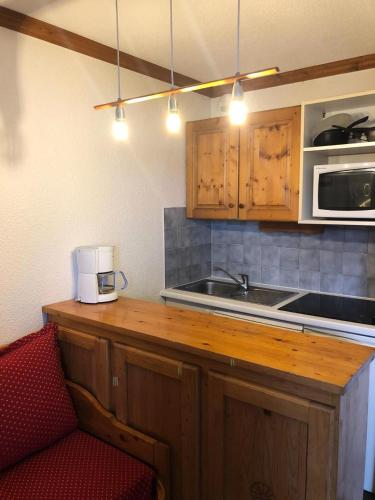 une cuisine avec un évier et un micro-ondes dans l'établissement Résidence Les Horizons d'Huez - maeva Home - Studio 4 personnes Confort MAE-7170, à Huez