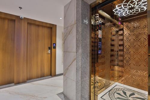 a lobby with a wooden door and a tile floor at Hotel Bawa Inn in Surat