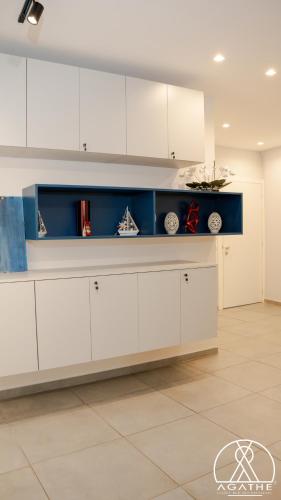 a kitchen with white cabinets and a blue shelf at Agathè Luxury Bed and Breakfast in Marina di Schiavonea