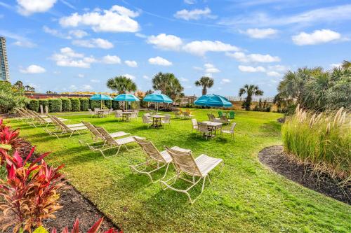 a group of chairs and tables with blue umbrellas at Ocean View Double Suite! Sleeps 4 Meridian Plaza 705 in Myrtle Beach