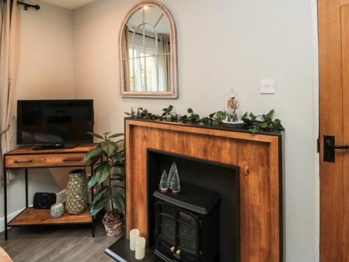 a fireplace with a christmasreath on top of it at Dodds Nook in Alnwick