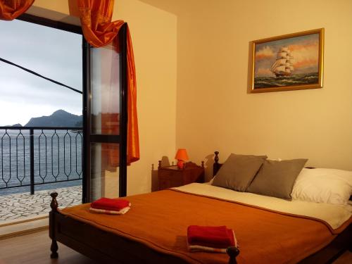 a bedroom with a bed and a large window at Apartments "Villa Mungos" Sobra in Sobra