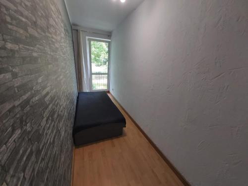 a room with a bench next to a brick wall at 2050 Zwycięstwa 23 - Tanie Pokoje - samodzielne zameldowanie - self check in in Poznań