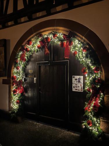an arch with christmas lights and areath on a door at Maison Dietenbeck in Wissembourg