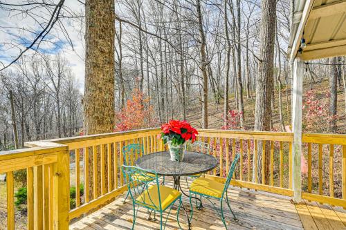 a table with chairs and a vase of flowers on a deck at 5 Mi to Blue Ridge Parkway Mountain Cabin in Cana in Fancy Gap