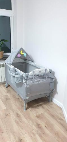 a gray bed in a room with a wooden floor at Apartament Chłodna 14 in Suwałki