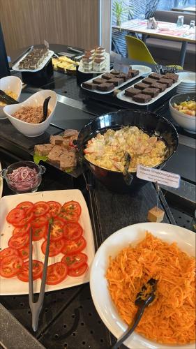 a buffet with different types of food on a table at HOTEL PREMIERE CLASSE Rouen Sud Oissel in Saint-Étienne-du-Rouvray
