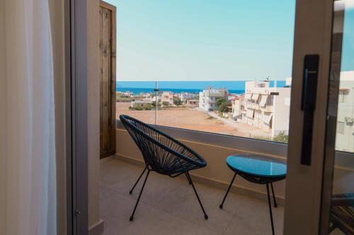 a balcony with two chairs and a view of the ocean at The Z Suites in Gournes