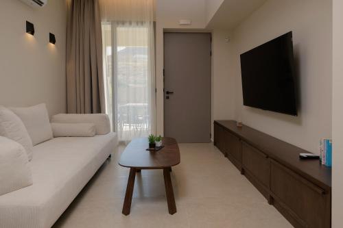 a living room with a white couch and a tv at The Z Suites in Gournes