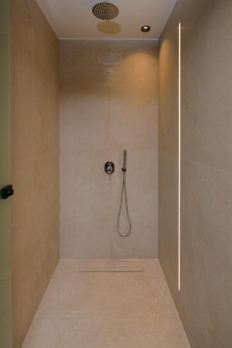 a bathroom with a shower with a shower head at The Z Suites in Gournes
