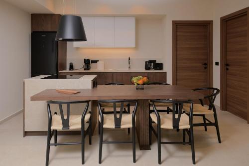 a kitchen and dining room with a wooden table and chairs at The Z Suites in Gournes