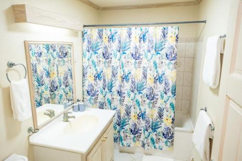 a bathroom with a shower curtain and a sink at Sweet Life Condo in Bridgetown