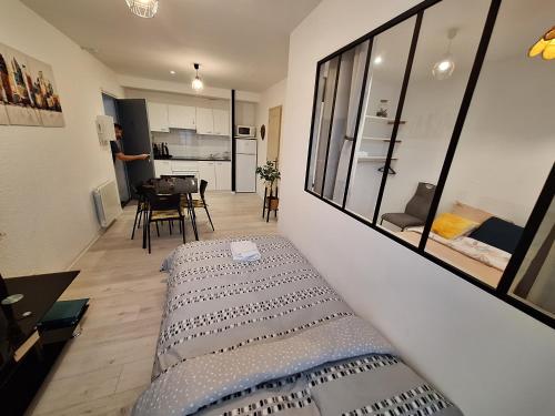 un salon avec un lit et une salle à manger dans l'établissement Joli T2 rénové bord plan d'eau, à Saint-Jean-dʼAngély