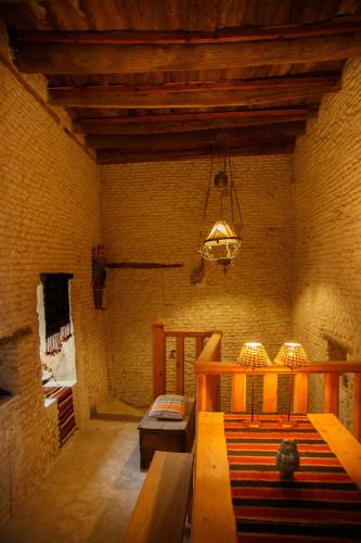 a room with a bench and a chandelier at Houch El Houdou in Tozeur