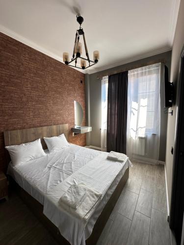 a bedroom with a large bed and a brick wall at Dili Hill in Dilijan