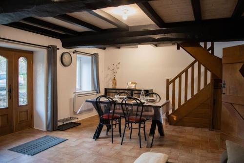 une salle à manger avec une table et des chaises et un escalier dans l'établissement Maison au bord de la rivière, à Saint-James