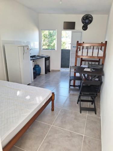 a kitchen with a refrigerator and a table and chairs at Casa da Maria Ubatuba in Ubatuba