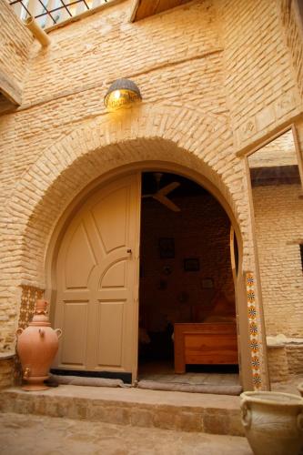 an archway with a large door in a building at Houch El Houdou in Tozeur