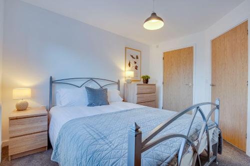 ein Schlafzimmer mit einem Bett mit einer blauen Bettdecke in der Unterkunft Stay Yorkshire Hamilton Mews Apartment in Doncaster