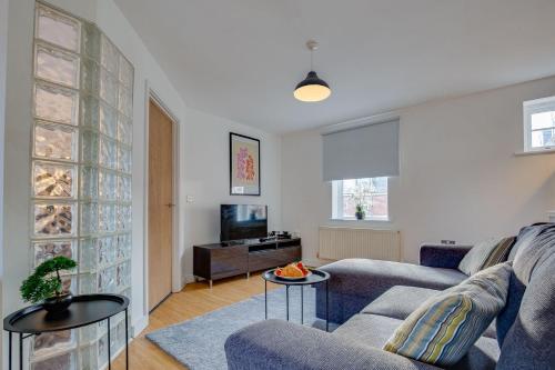 a living room with a couch and a tv at Stay Yorkshire Hamilton Mews Apartment in Doncaster