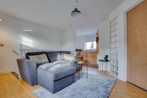 a living room with a couch and a table at Stay Yorkshire Hamilton Mews Apartment in Doncaster