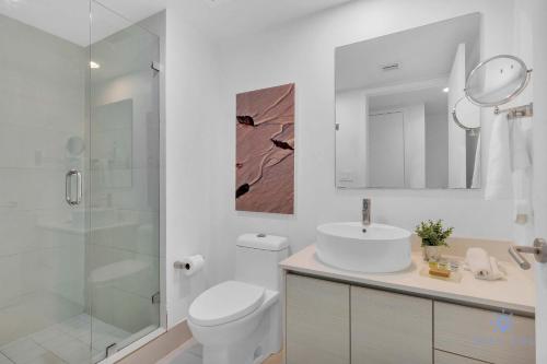 Un baño con inodoro, lavabo y ducha. en Lovely Studio with Amazing View gym and amenities, en Hallandale Beach