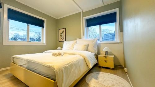 a bedroom with a large bed with two windows at Cozy apartment with free parking in Jar